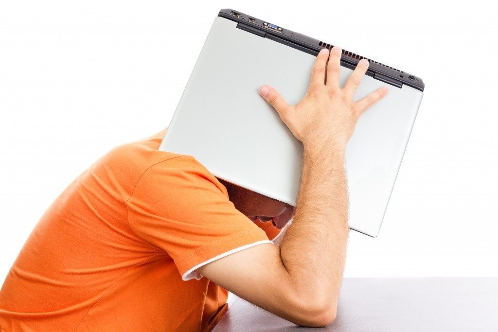 man laptop on head orange shirt